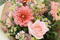 The Peach Billini bouquet by Wild About Flowers features a hand-tied mix of large pink dahlia, pale pink roses, small white daisies, seasonal summer blooms, and lush greenery for a delicate, fresh arrangement.