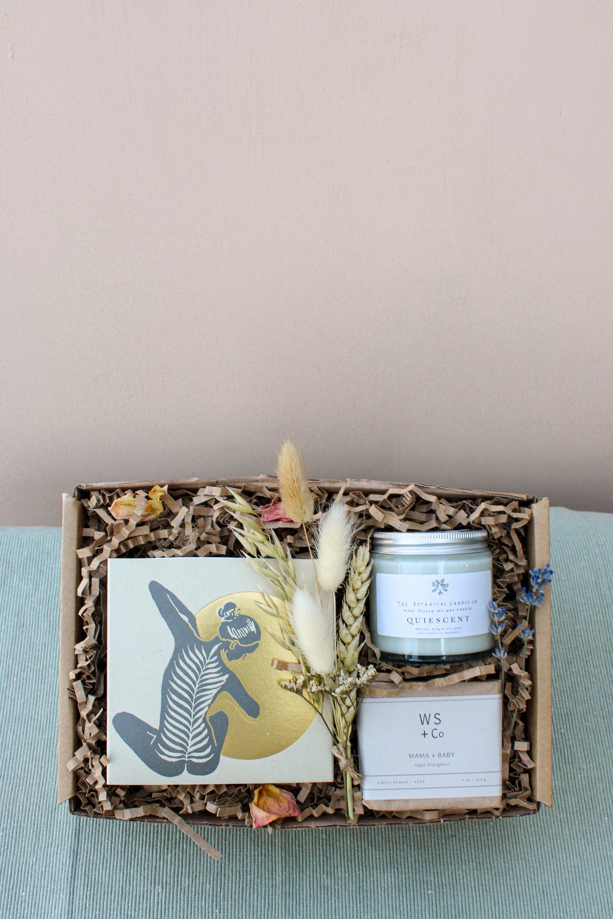 The Wild About Flowers New Mama Gift Box includes shredded paper filling, an abstract figure card, dried flowers bundle, WS + Co candle, Quiescent jar, and hypo-allergenic soap—perfect for ultimate relaxation.