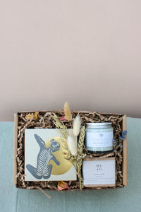 The Wild About Flowers New Mama Gift Box includes shredded paper filling, an abstract figure card, dried flowers bundle, WS + Co candle, Quiescent jar, and hypo-allergenic soap—perfect for ultimate relaxation.