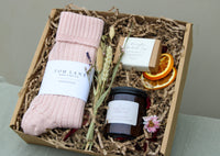 Winter Warmers Gift Box by Wild About Flowers: Enjoy pink alpaca wool socks, a "Starlight" candle, chamomile and calendula soap, and dried orange slices. Each piece is nestled in crinkled paper for the perfect winter treat.