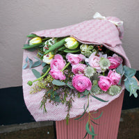 The 'Armful of Love' Valentines wrap by Wild About Flowers features pink and white roses and tulips in textured pink cloth, making it the perfect romantic bouquet for Valentine’s Day.