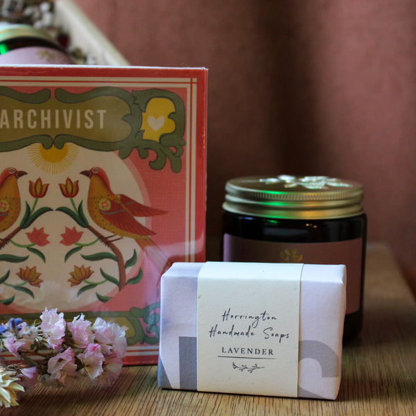 Archivist matches, Herrington Handmade Soaps lavender bar, and jar on a wooden surface with a blurred background