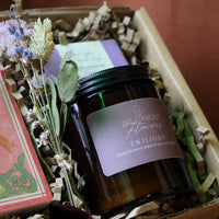 Candle labeled 'Wild About Flowers Twilight' in a decorative box with flowers and cards.