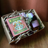 Gift box with a book and a candle on a wooden surface
