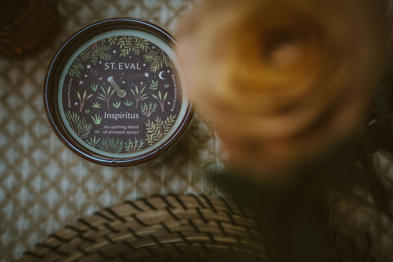 Top-down view of a St Eval Inspiratus scented candle tin with botanical label design