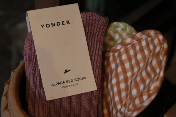 Alpaca bed socks with a 'Yonder' label on a blurred background
