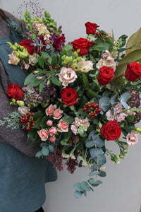 A person holding the Mulled Wine Hand Tied bouquet from Wild About Flowers.